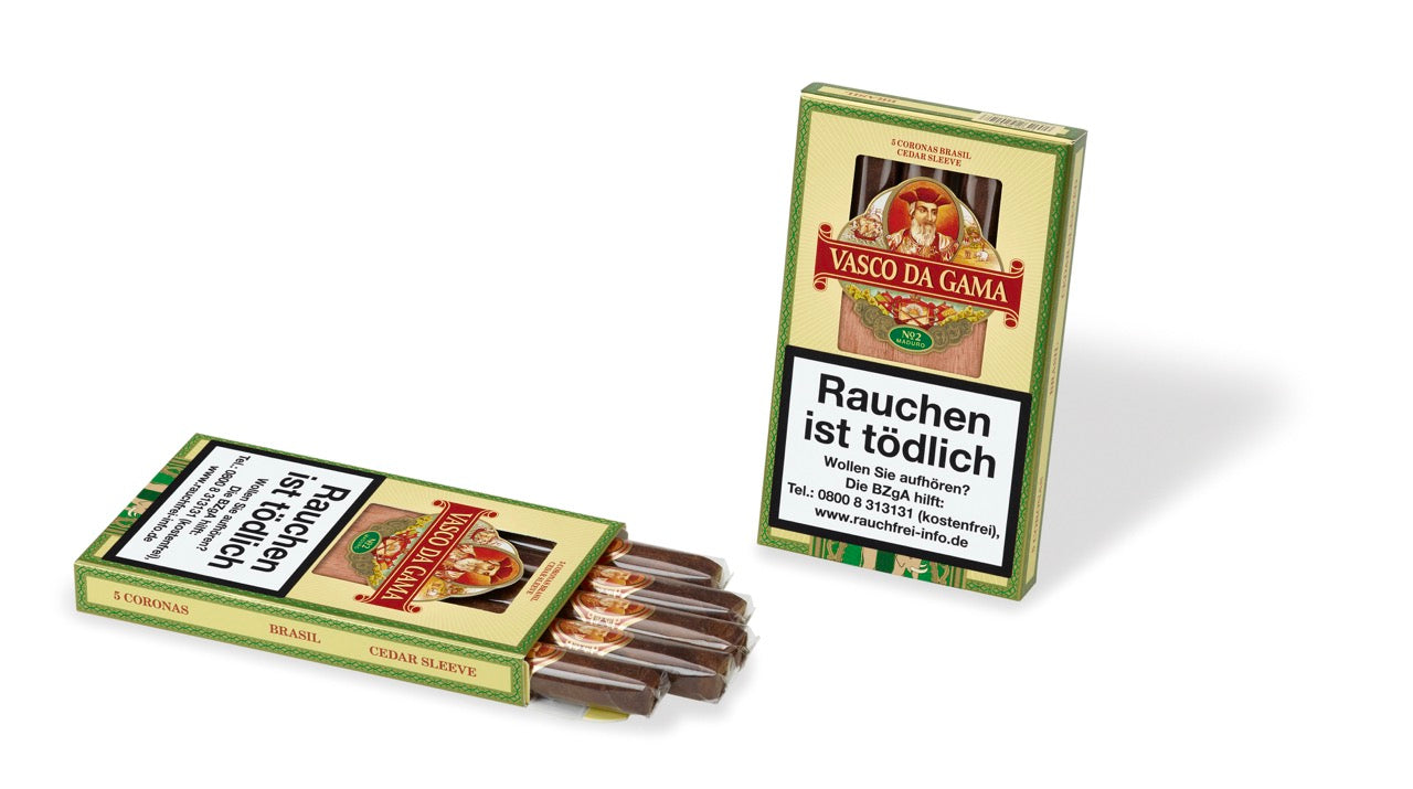 Vasco Da Gama Brasil 920 Corona No. 2 Zigarren – zwei Packungen im Fokus: Eine Zigarrenschachtel steht geschlossen, davor liegt eine weitere Packung geöffnet mit sichtbaren Corona-Zigarren. Zeigt die hochwertige Präsentation und Vielfalt der Vasco Da Gama Zigarren.